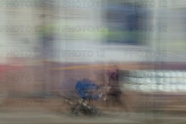 Abstract image of a woman pushing a pram in city captured using ICM intentional camera movement