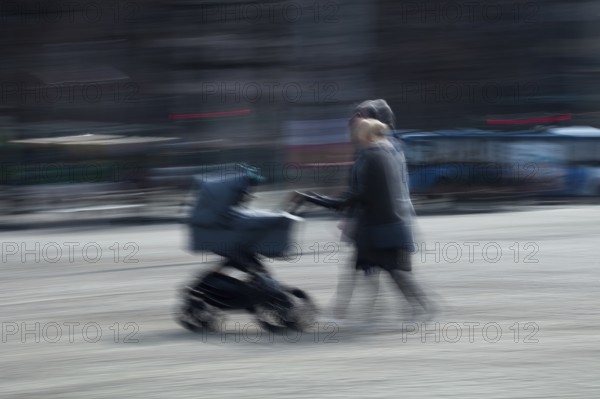 Abstract image of a couple pushing a pram in city captured using ICM intentional camera movement