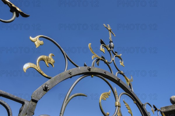 Blue sky and wrought iron gate to the cemetery in Maria-Thann, Allgäu, Swabia, Bavaria, Germany