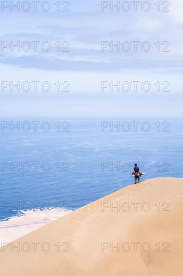 Young man looking at the view from Alto los Verdes, in Atacama Desert. Iquique, Tarapaca Region,