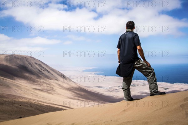 Young man looking at the view from Alto los Verdes, in Atacama Desert. Iquique, Tarapaca Region,