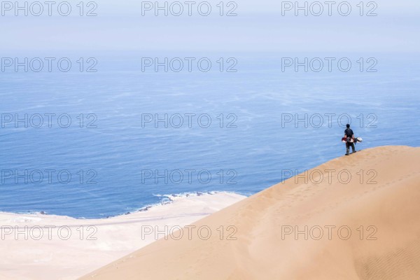 Young man looking at the view from Alto los Verdes, in Atacama Desert. Iquique, Tarapaca Region,