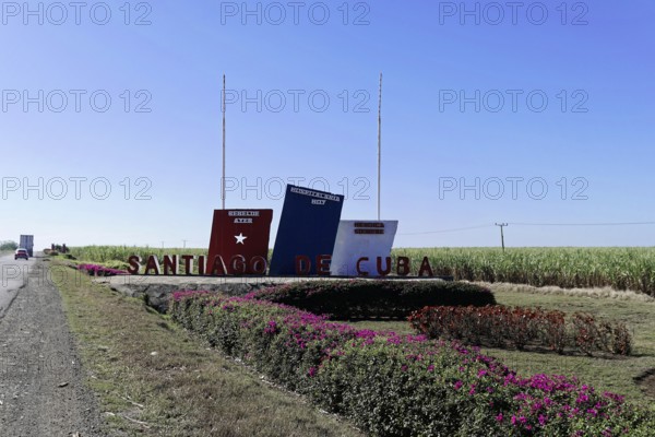 Sign with the word 'Santiago de Cuba' on a field with blue sky, Cuba, Greater Antilles, Caribbean,