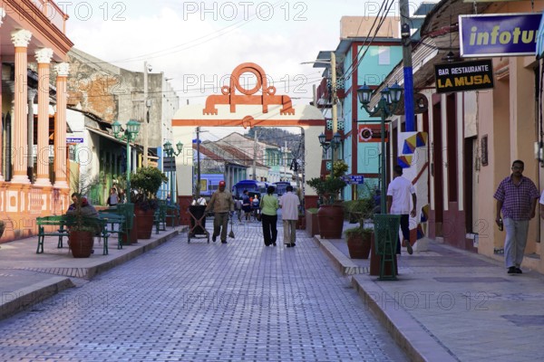 Baracoa, Cuba, Central America, Busy street with many people and colorful colonial buildings,
