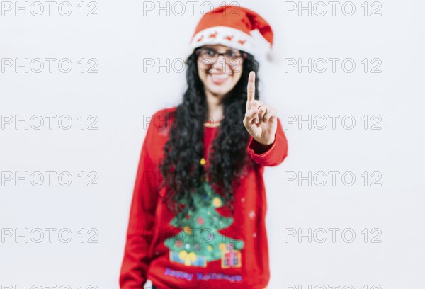 Happy girl in Christmas hat counting number ONE, isolated. Smiling girl in Christmas sweater