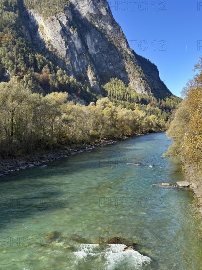 A lively river flows between steep mountains, surrounded by autumn leaves, Drau, Drauradweg, near