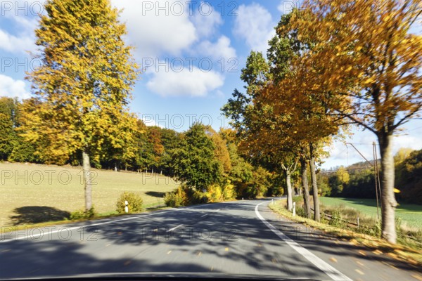 Car ride over winding country road, autumn leaves, sunny autumn weather, motion blur, Barntrup,