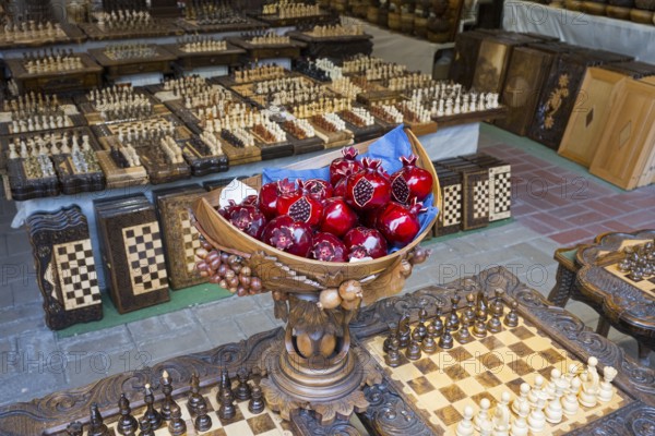 Colourful pomegranates in intricately carved wooden balls on checkerboards, Vernissage Market,