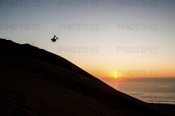 Sandboarding in Cerro Dragon, a sand dune located next to the city of Iquique, in Atacama Desert.