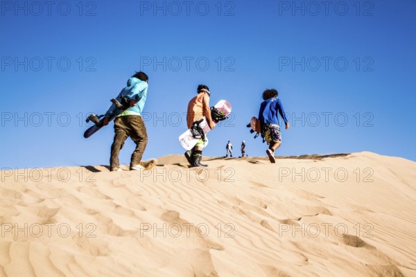 Sandboarding in Cerro Dragon, a sand dune located next to the city of Iquique, in Atacama Desert.