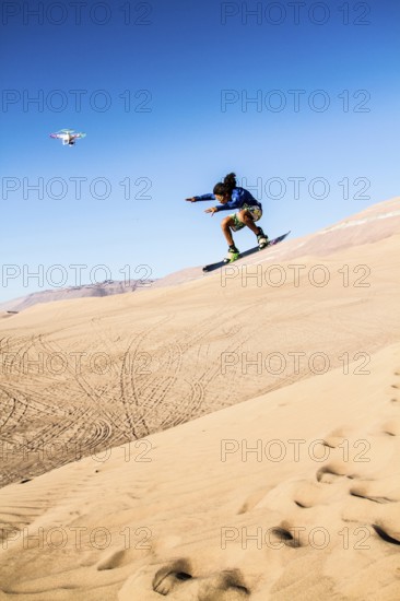 Sandboarding in Cerro Dragon, a sand dune located next to the city of Iquique, in Atacama Desert.