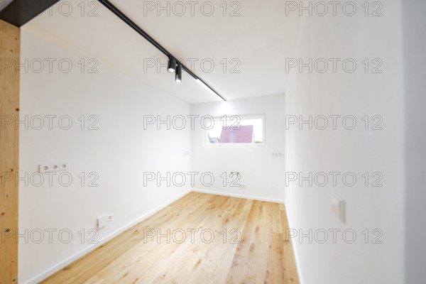 Light small room with oak floor and window, ready for furnishing and use, house renovation, energy