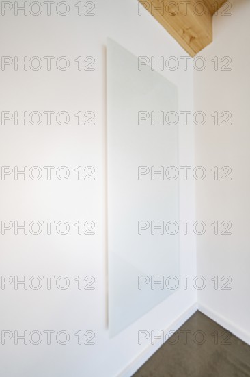 Large white glass wall panel in a bright room with wooden beam ceiling, house renovation, energy