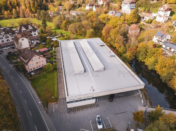 Sports hall in autumn surroundings with colorful trees and adjacent street, Walter Lindner