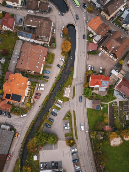 Aerial view of a village with a river running between autumn trees and houses, Calmbach, Bad