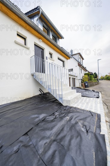 Straight-lined entrance with metal railing and dark door, functional and functional design, house