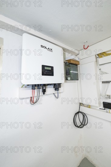 Wall-mounted SOLAX inverter in bright technical room, house renovation, climate renovation,