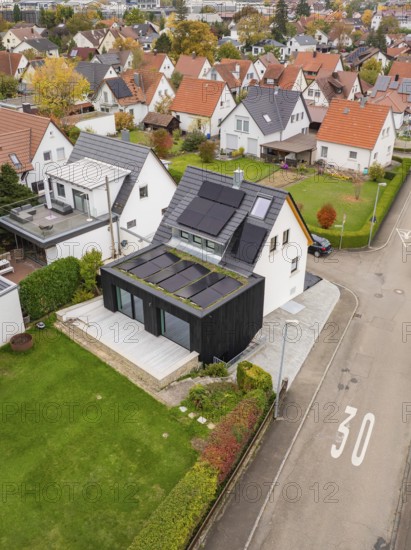 Aerial view of a house on a Tempo 30 road with PV on the roof and a green extension, with a