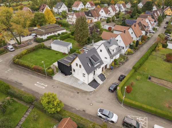 Wide angle aerial view of a quiet settlement with modernized house between well-kept gardens and
