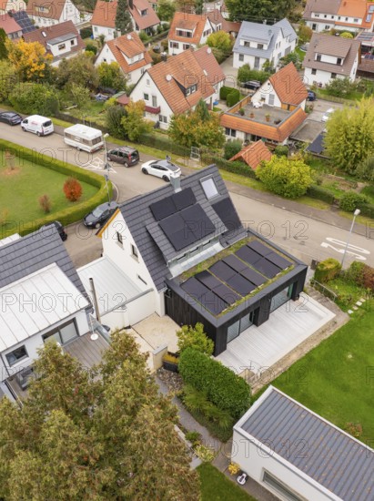 Top view shows PV modules and covered terrace at a modern extension with large wooden deck and