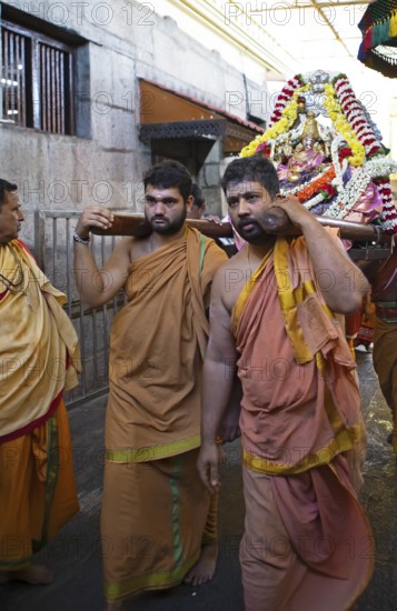 Puja at Chamundeswar Hindu Temple on Chamundi Hill, Indian men wear the statue of a Hindu goddess,