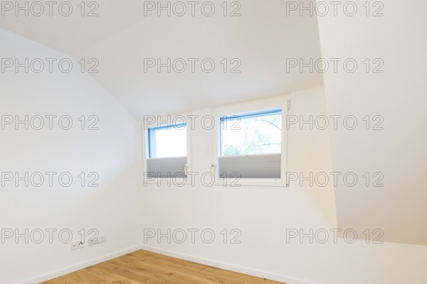 Bright room under the sloping roof with two windows and pleated blinds, house renovation, air