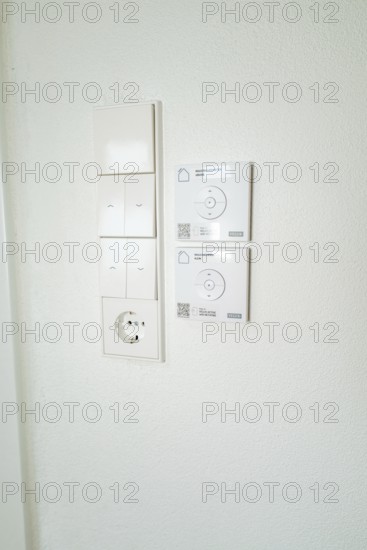 Wall panel with light switches, power outlet and smart home control in simple white, house