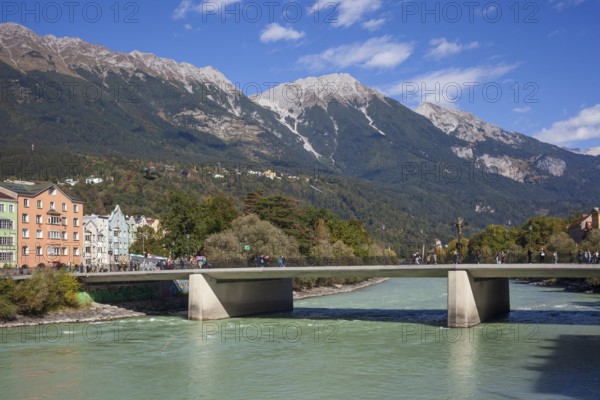 Colourful row of houses in Mariahilfstraße on the Inn River, Inn Bridge and mountains of the