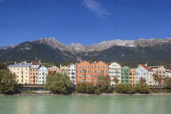Colourful row of houses in Mariahilfstraße on the Inn River and mountains of the Karwendel North