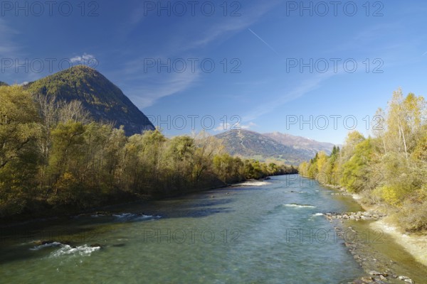 Wide river snakes through an autumnal valley, quiet sky with fine contrails, Lienz, Drau cycle