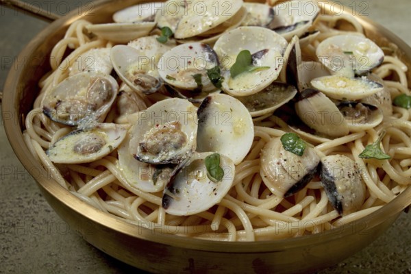 Spaghetti with vongole clams, in cream sauce, carbonara, in a brass pan, homemade, top view, no