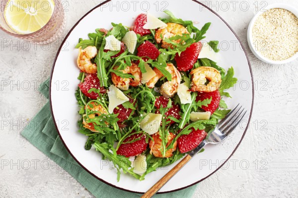 Fresh shrimp salad with arugula, grapefruit, and parmesan served in a bowl