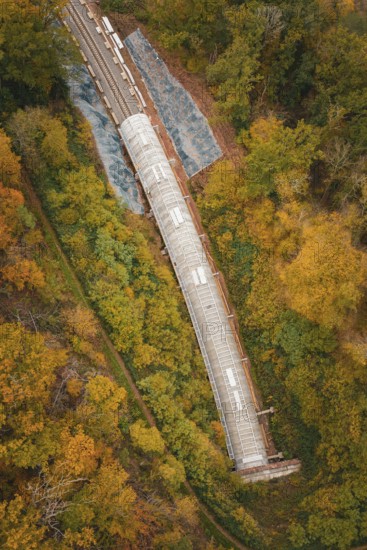 Aerial view of a railway tunnel in a landscape surrounded by autumn trees, Hermann-Hesse-Bahn