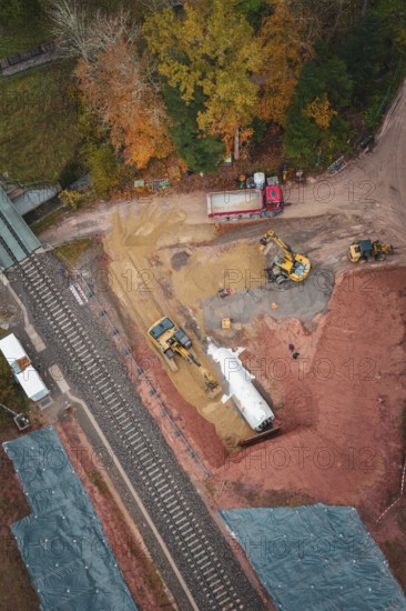 Construction work with heavy machinery on a railway line in autumn forest, Hermann-Hesse-Bahn
