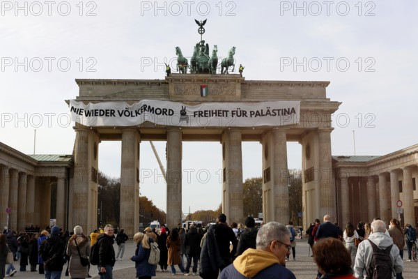 Several activists drop a banner with the inscription Never again genocide, freedom for Palestine