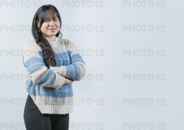 Attractive young Asian woman with arms crossed isolated. Portrait of beautiful and smiling Asian