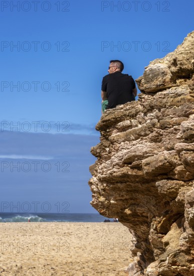Tourists watch the waves of the Atlantic on the rocky plateau of Sito, also known as Forte São