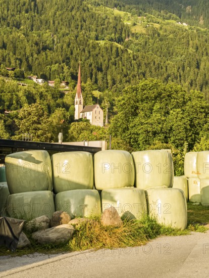 Agricultural structures with hay bales sealed in plastic near a farm on the outskirts of Oetz in