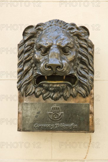 Bronze letterbox in the shape of a lion's head with the inscription Correos y Telegraficos in Old