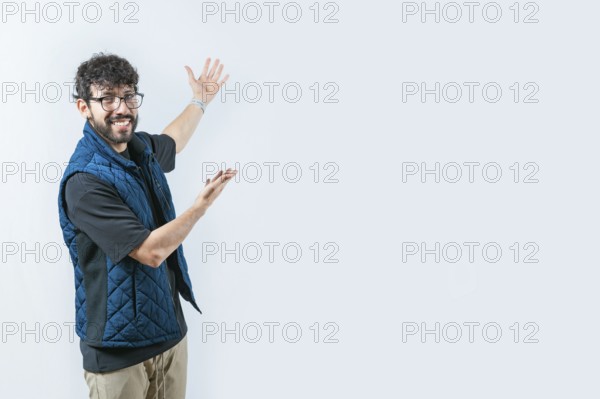 Handsome guy welcoming you on isolated bakground. Smiling Handsome Man Presenting something