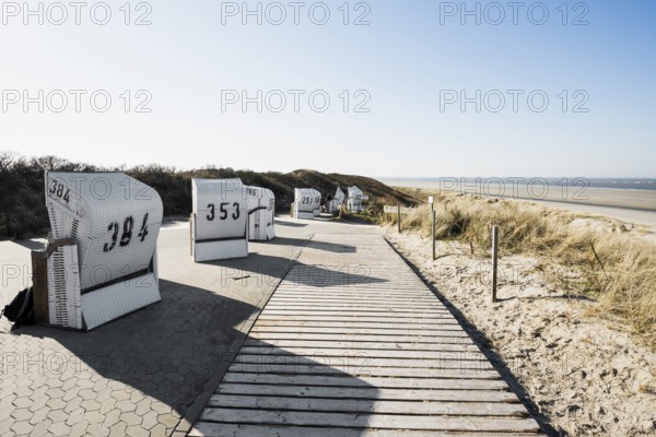 Beach chairs in the dunes and blue sky in winter, Spiekeroog, East Frisian Islands, Lower Saxony,
