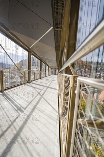 Modern bridge with long shadows and a network of metallic mesh along the sides, ZOB Calw, Hermann