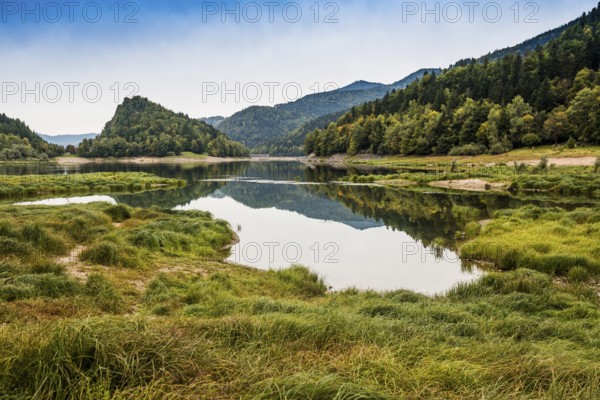 Picturesque mountain lake with water reflections in autumn, Lac de Kruth-Wildenstein, Kruth,