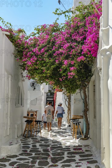 Mykonos, Cyclades, Greece - Tourists stroll through colorful alleys of the old town in Mykonos Town