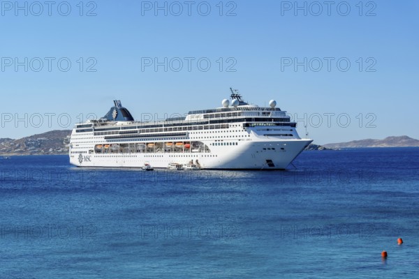 Mykonos, Cyclades, Greece - Cruise ship MSC Lirica is located in Mykonos Harbour Bay. Cruise ships