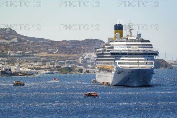Mykonos, Cyclades, Greece - Cruise ship COSTA FORTUNA is located in the bay against the backdrop of