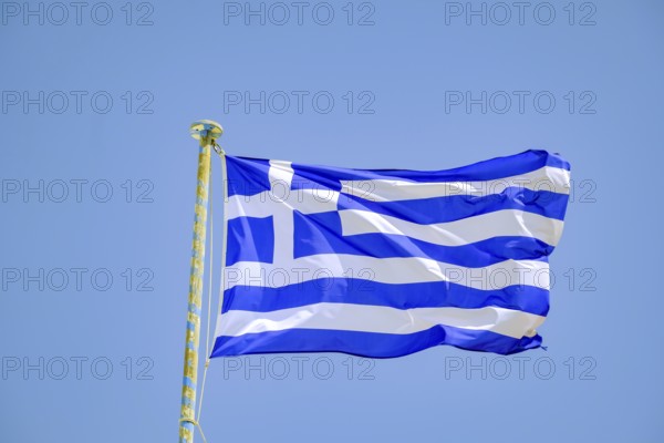 Ano Mera, Mykonos, Cyclades, Greece - Greek national flag fluttering on the flag pole on the roof