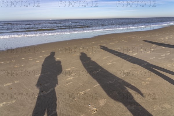 East beach of the East Frisian island of Spiekeroog, shade of walkers on the beach, Lower Saxony,