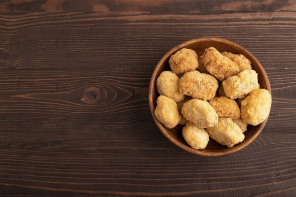 Fried crispy Chicken Nuggets on brown wooden background. top view, flat lay, copy space