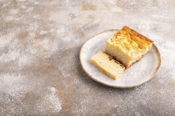 ?ottage cheese ?asserole, Curd cake, with dried apricots and raisins on brown concrete background,
